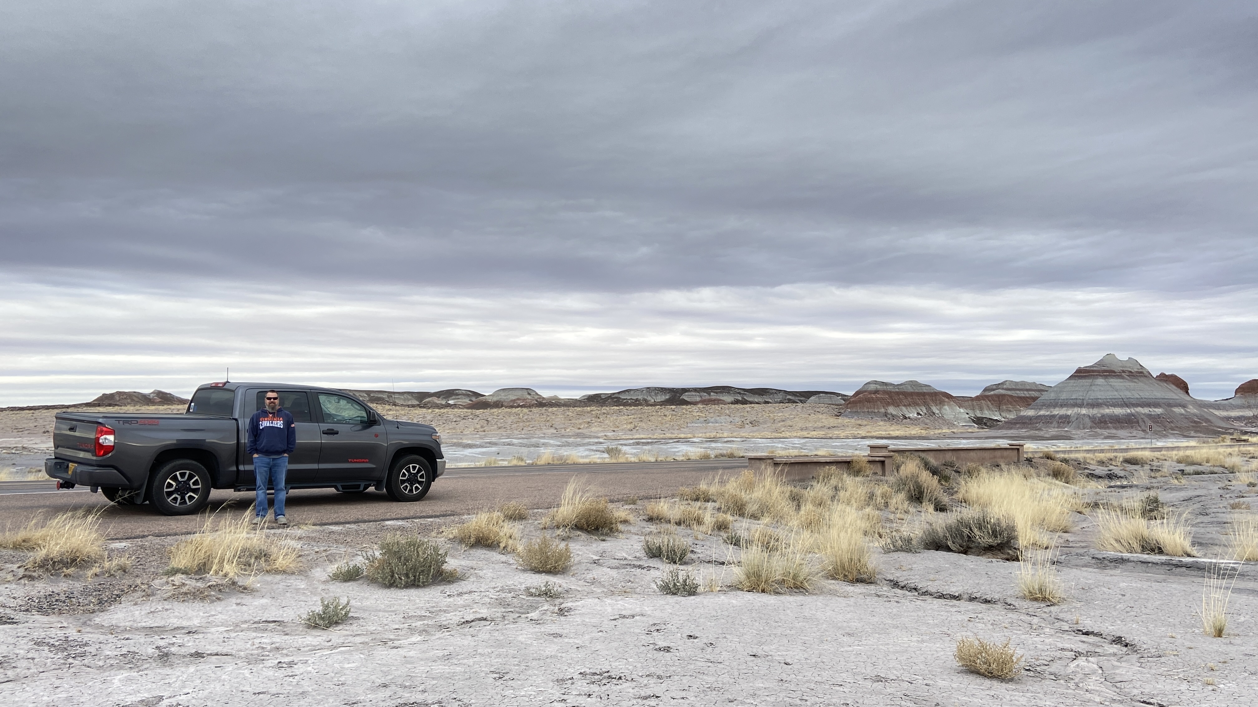 Showing a dark grey truck in an open area of land. 